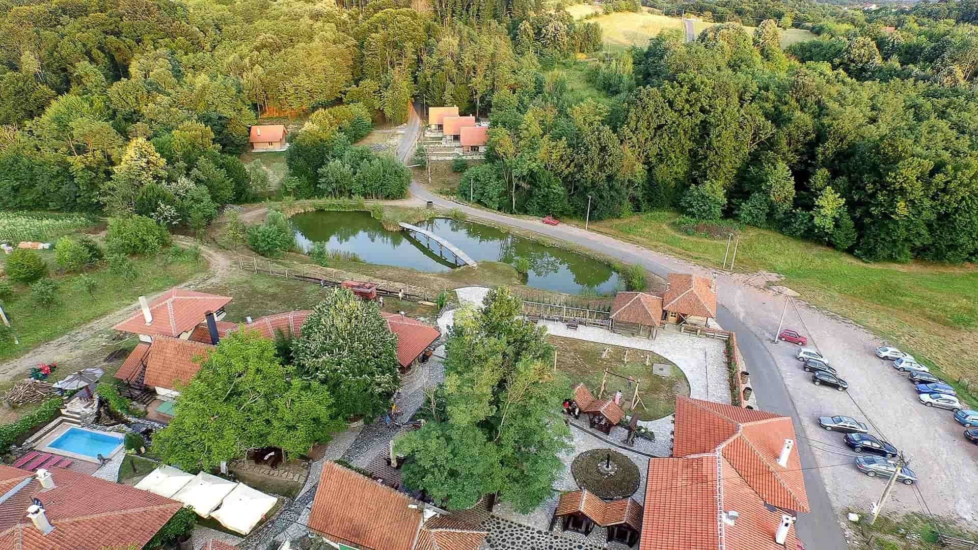 Etno selo Babina reka iz vazduha: jezero, bungalovi, restorani i bazen među šumom